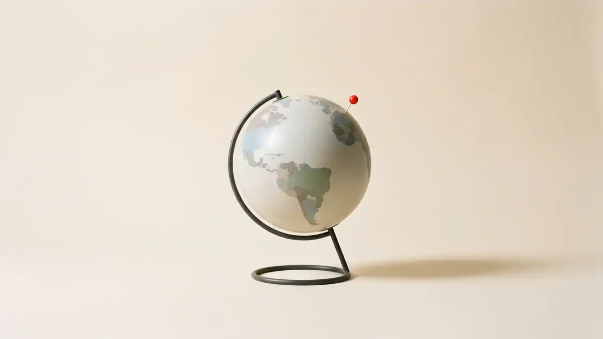 Chincheta roja sobre un globo terráqueo, bodegón cenital editorial — mejores sitios para viajar solo — unente