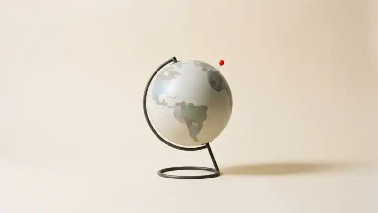 Chincheta roja sobre un globo terráqueo, bodegón cenital editorial — mejores sitios para viajar solo — unente
