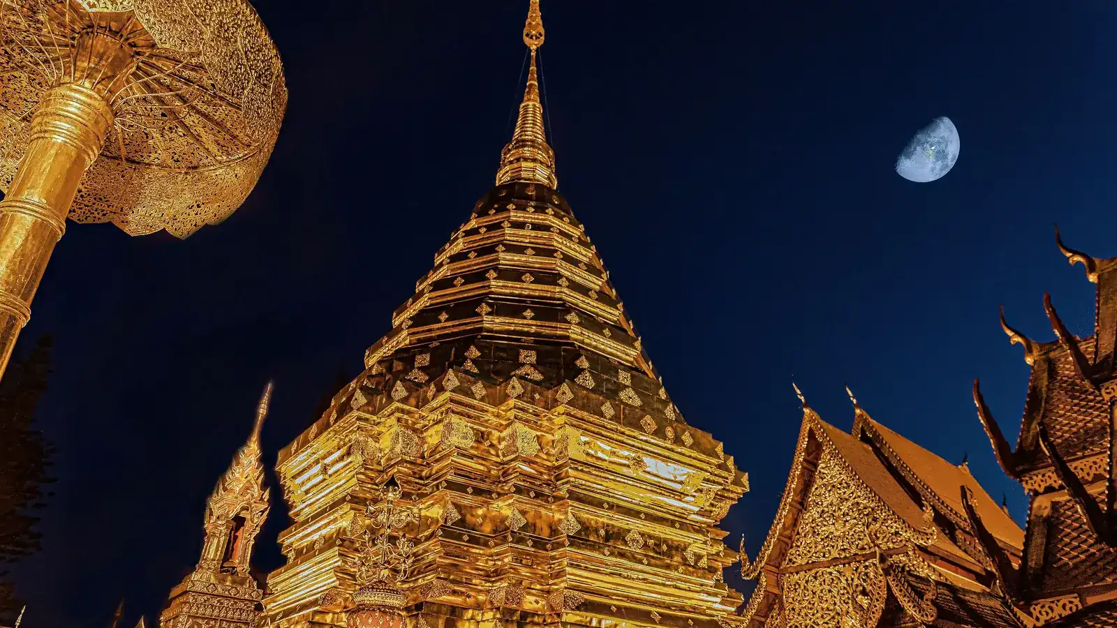 Chedi dorado del templo Doi Suthep en Chiang Mai, Tailandia, iluminado al anochecer — de los destinos más baratos para viajar solo — unente