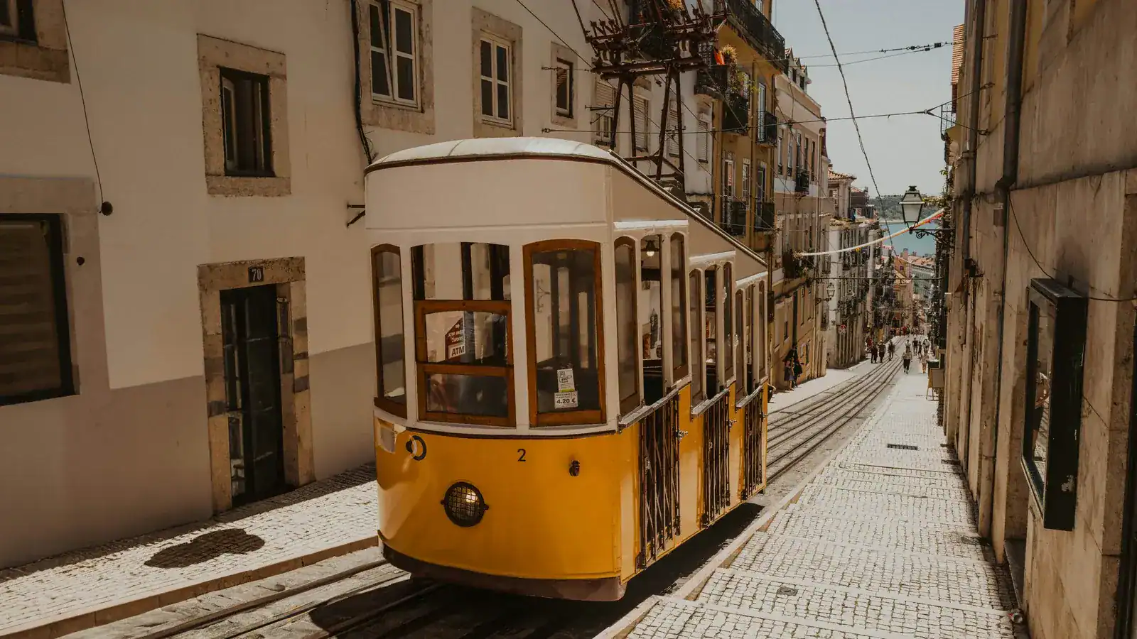 Tranvía amarillo en una calle empedrada de Lisboa, Portugal — de los mejores sitios para viajar solo en Europa — unente