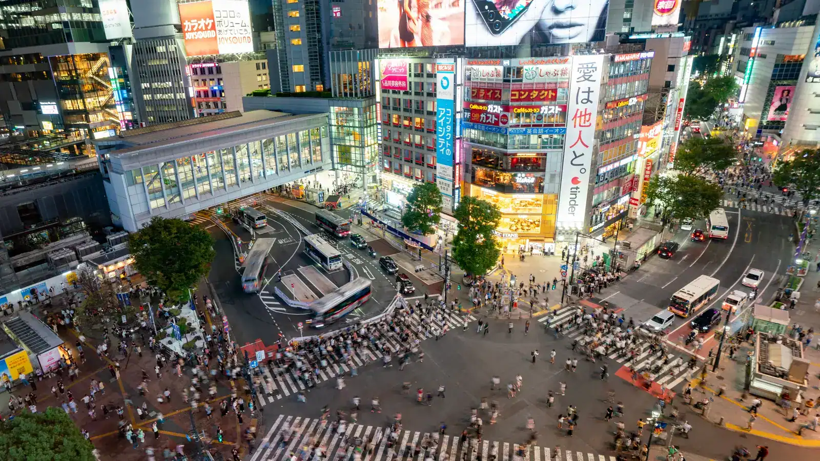 Peatones cruzando Shibuya en Tokio, Japón, de noche — destinos para viajar solo con seguridad y buen transporte — unente